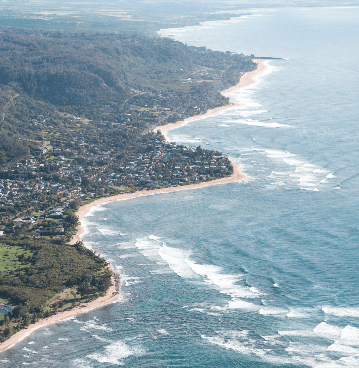 Aerial view of Oahu's North Shore coastline with waves breaking along sandy beaches